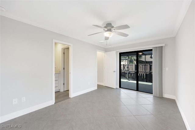 spare room with ceiling fan, crown molding, tile patterned floors, and baseboards