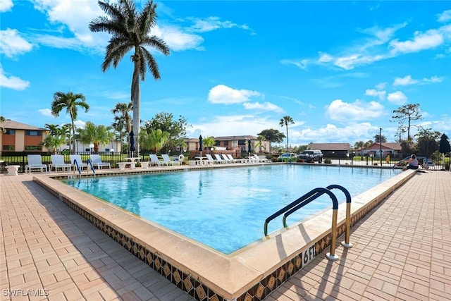 view of pool with a patio area and fence