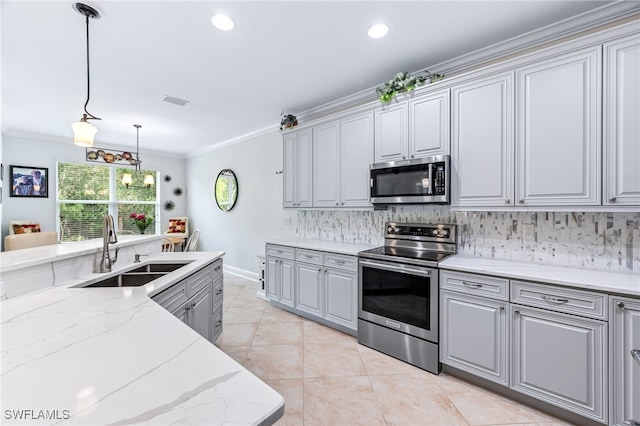 kitchen with gray cabinetry, stainless steel appliances, a sink, tasteful backsplash, and crown molding