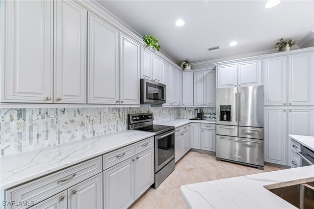 kitchen featuring light stone counters, light tile patterned flooring, visible vents, appliances with stainless steel finishes, and backsplash