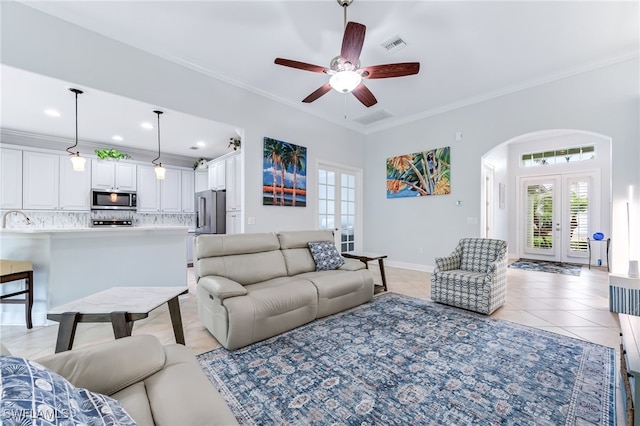 8732 Banyan Bay Blvd, Fort Myers, FL 33908 - living room with arched walkways, light tile patterned floors, healthy amount of natural light, crown molding, and a ceiling fan