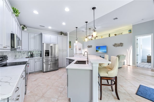 8732 Banyan Bay Blvd, Fort Myers, FL 33908 - kitchen featuring stainless steel appliances, backsplash, a large island, light tile patterned floors, and ornamental molding