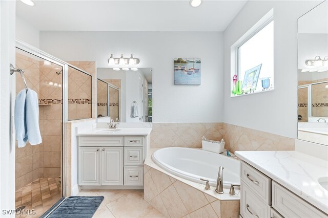 bathroom featuring two vanities, a sink, a shower stall, tile patterned flooring, and a bath