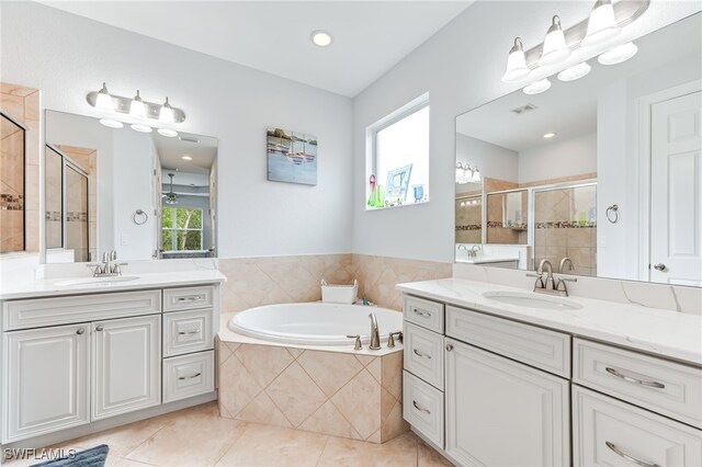 bathroom featuring a bath, a shower stall, a sink, and tile patterned floors