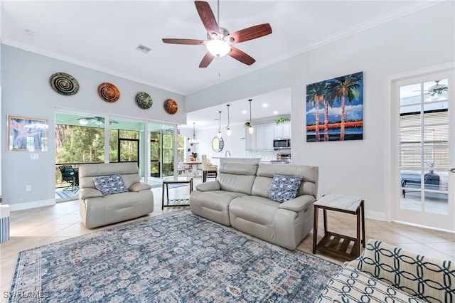 living room featuring a ceiling fan, light tile patterned flooring, crown molding, and baseboards