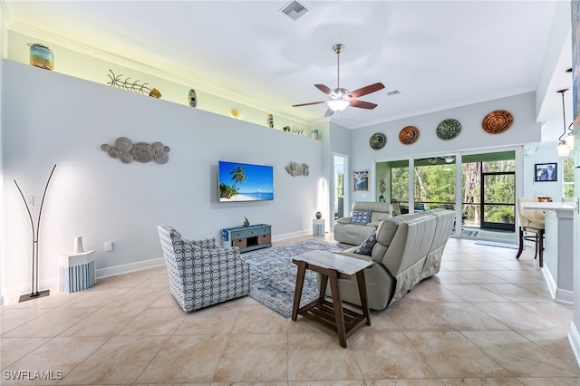 living room with ornamental molding, visible vents, baseboards, and light tile patterned flooring