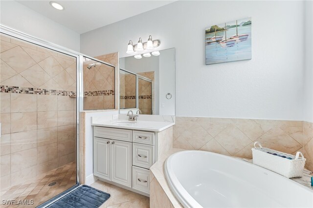 bathroom with vanity, a shower stall, a bath, and tile patterned floors