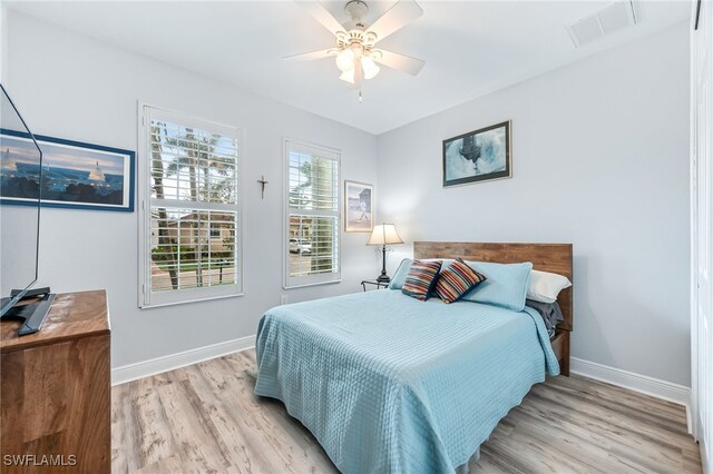 bedroom featuring baseboards, visible vents, and light wood finished floors