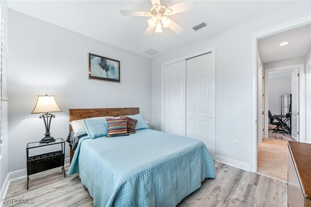 bedroom with a closet, visible vents, light wood-style flooring, a ceiling fan, and baseboards