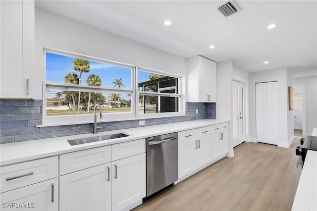 kitchen with visible vents, dishwasher, light wood-style floors, white cabinetry, and a sink