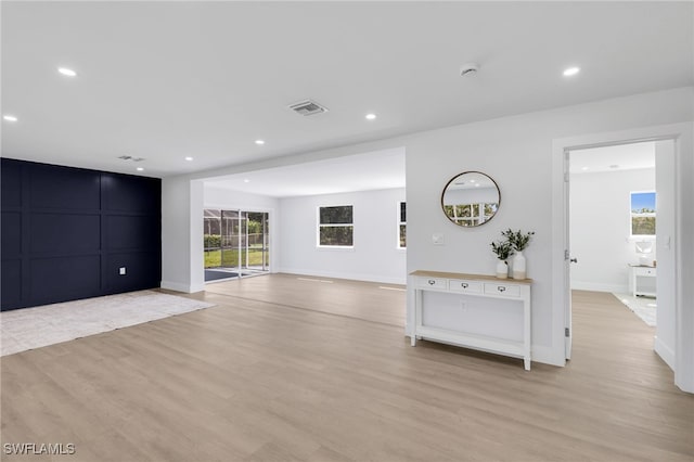 unfurnished living room with light wood-style flooring, visible vents, baseboards, and recessed lighting