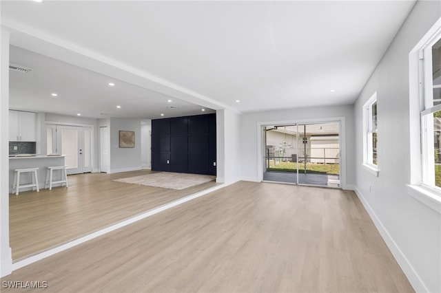 unfurnished living room with light wood finished floors, visible vents, baseboards, and recessed lighting