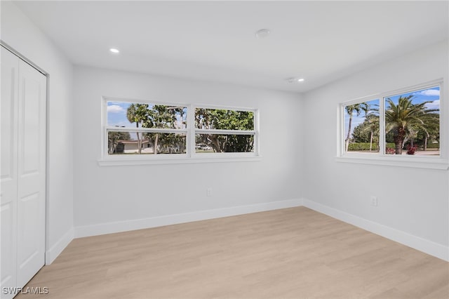 unfurnished bedroom with light wood finished floors, multiple windows, recessed lighting, and baseboards