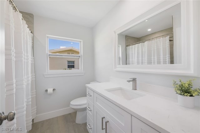 full bathroom with toilet, baseboards, wood finished floors, and vanity