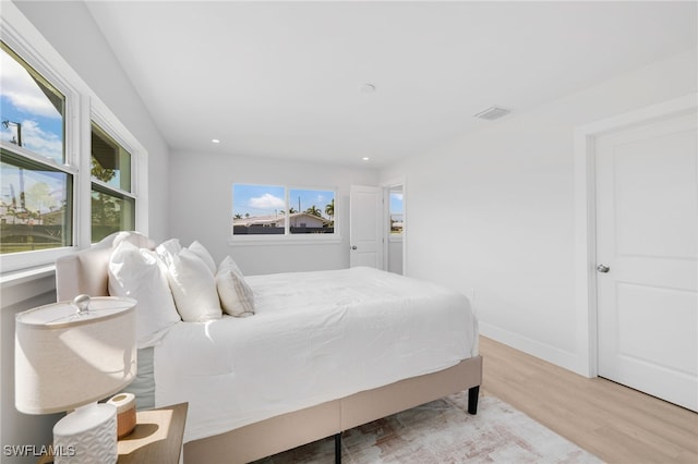 bedroom with multiple windows, recessed lighting, wood finished floors, and baseboards