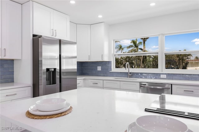 kitchen featuring appliances with stainless steel finishes, light countertops, and a sink