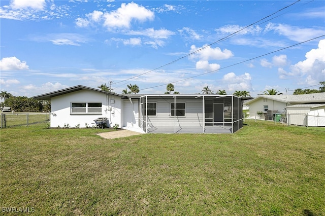 back of property with a lawn, a fenced backyard, and a sunroom