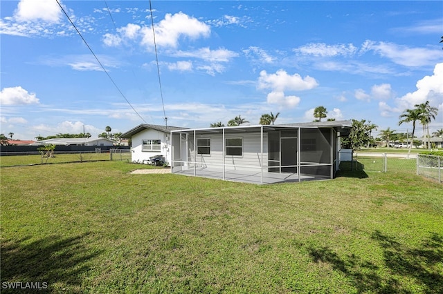 rear view of house featuring a patio, a lawn, fence, and a sunroom