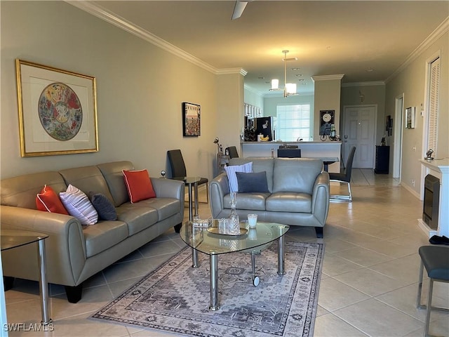 living room featuring a notable chandelier, light tile patterned flooring, baseboards, and crown molding