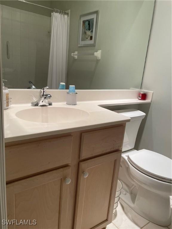 bathroom with curtained shower, vanity, toilet, and tile patterned floors