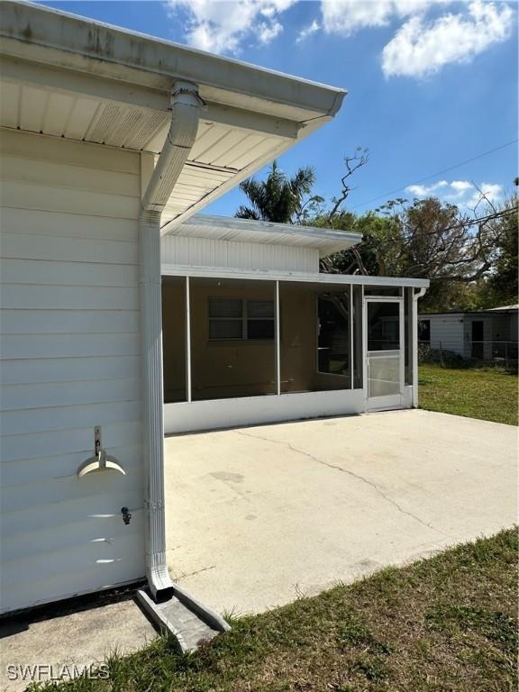 1440 Ricardo Ave, Fort Myers, FL 33901 - rear view of property with a patio, an attached carport, and a sunroom