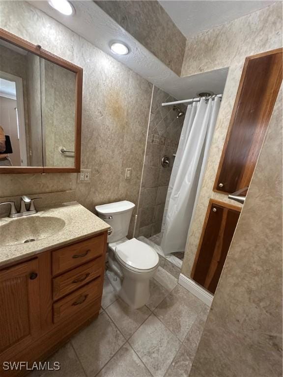 bathroom with vanity, a shower stall, and toilet