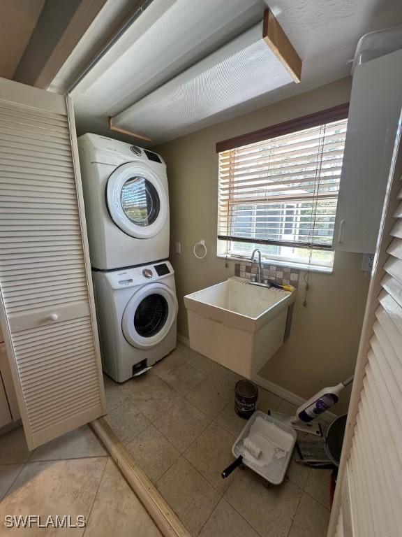 1440 Ricardo Ave, Fort Myers, FL 33901 - washroom with light tile patterned flooring, laundry area, and stacked washer / drying machine