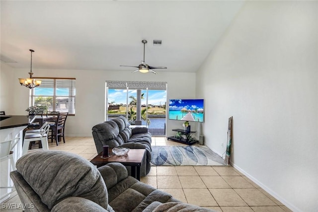 living room featuring light tile patterned flooring, visible vents, plenty of natural light, and ceiling fan with notable chandelier