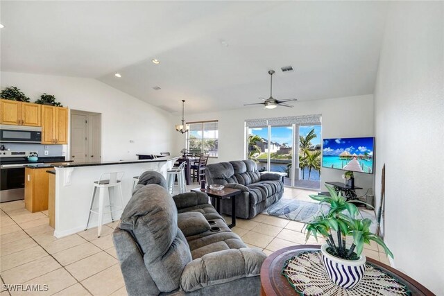 living area with visible vents, lofted ceiling, light tile patterned flooring, and ceiling fan with notable chandelier