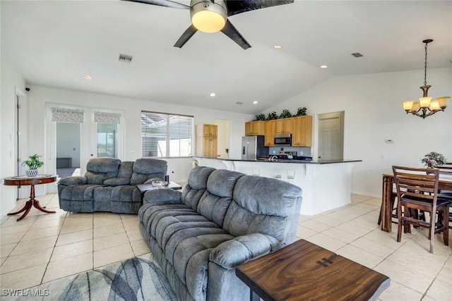 living area featuring vaulted ceiling, light tile patterned floors, ceiling fan with notable chandelier, and visible vents