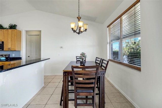 dining space featuring a chandelier, baseboards, light tile patterned flooring, and vaulted ceiling