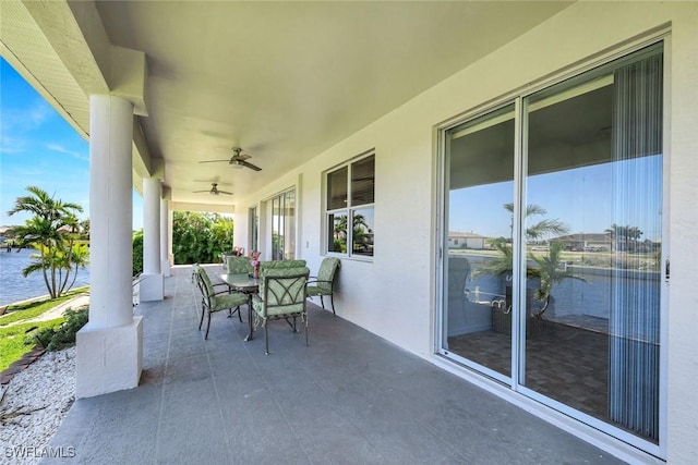 view of patio / terrace featuring outdoor dining area, a water view, and ceiling fan