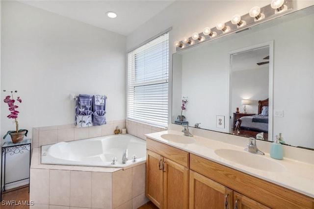 bathroom with double vanity, a bath, ensuite bathroom, and a sink