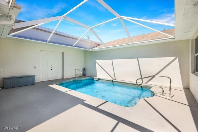 pool featuring glass enclosure and a patio