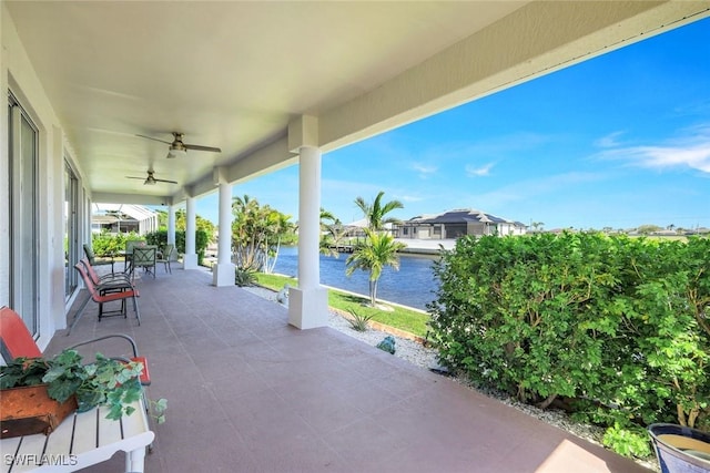 view of patio with a water view and ceiling fan