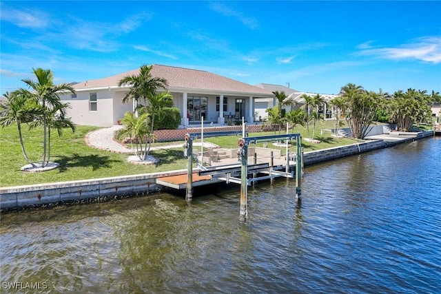 dock area with a yard, a water view, and boat lift