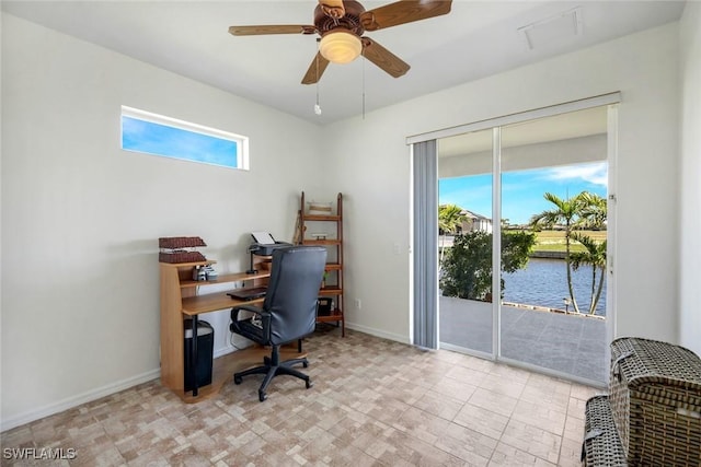 office space featuring baseboards, plenty of natural light, a ceiling fan, and a water view