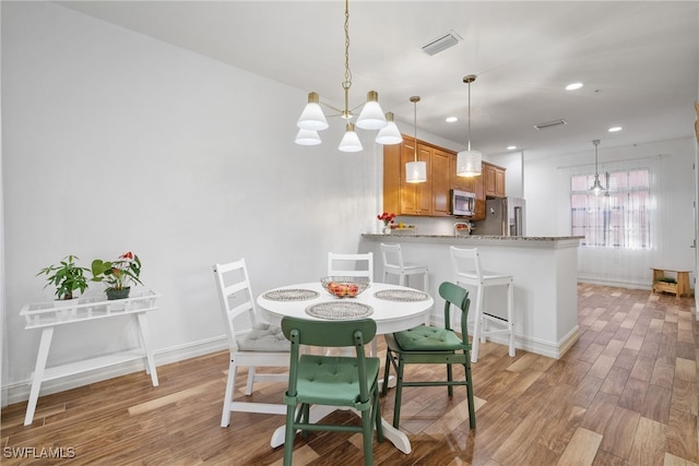 dining area with recessed lighting, visible vents, baseboards, light wood-style floors, and an inviting chandelier