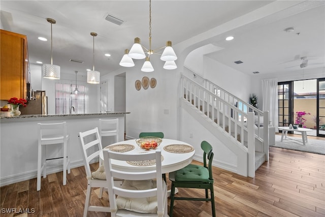 dining area featuring light wood-style flooring, recessed lighting, visible vents, and stairway