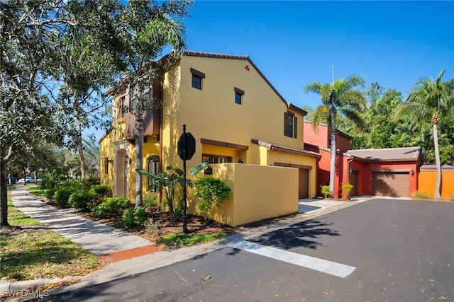 view of front facade featuring driveway, an attached garage, and stucco siding