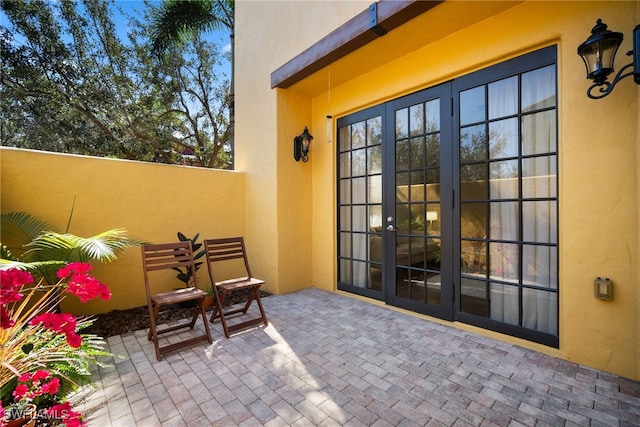 view of exterior entry with a patio area and stucco siding