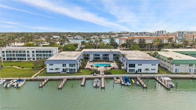 rear view of house featuring an outbuilding, a water view, a lawn, and a swimming pool