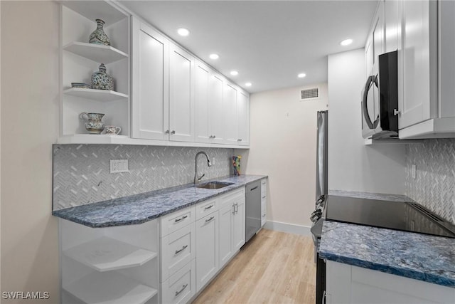 kitchen featuring stainless steel appliances, visible vents, open shelves, and a sink