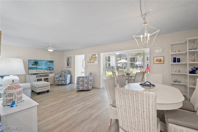 dining room featuring light wood-style floors and ceiling fan with notable chandelier