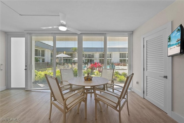 dining room featuring a ceiling fan, light wood-type flooring, and baseboards