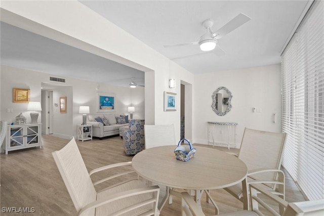 dining space featuring visible vents, ceiling fan, and wood finished floors