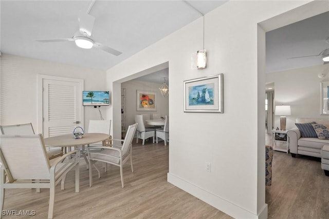 dining area featuring light wood-style floors, ceiling fan, and baseboards