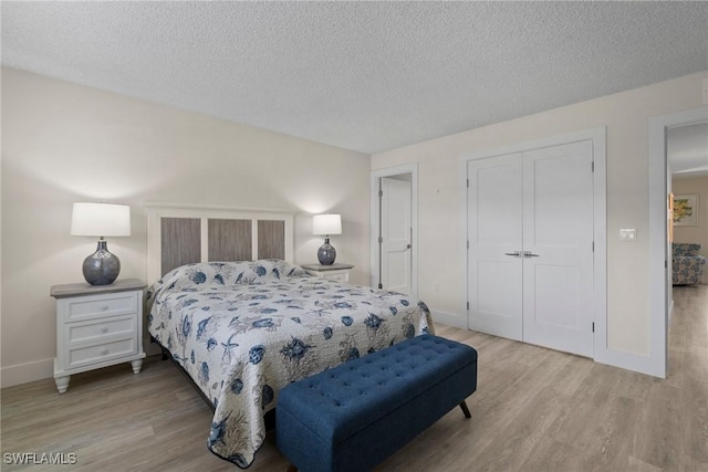 bedroom featuring a closet, baseboards, and wood finished floors