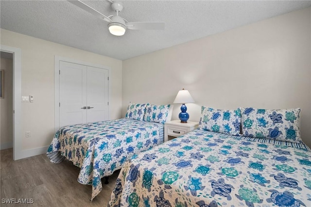 bedroom with a closet, ceiling fan, a textured ceiling, wood finished floors, and baseboards