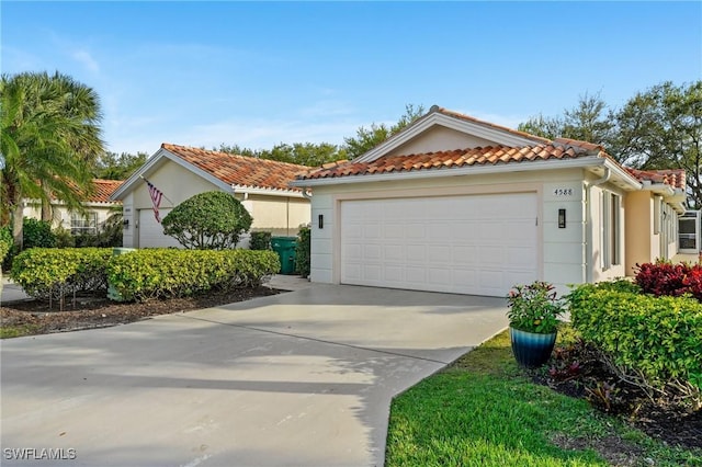 mediterranean / spanish-style home featuring a garage, a tile roof, and stucco siding